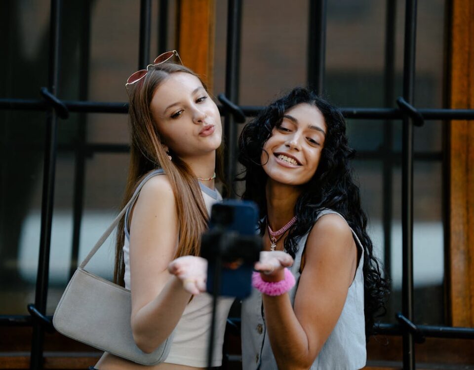 Parcerias no Instagram: Como Colaborar com Influenciadores para Aumentar Seguidores Young Fashionable Girls Taking a Picture with a Smartphone on a Tripod