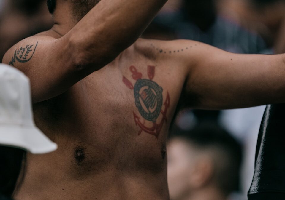 5 apps para acompanhar o Corinthians em tempo real A shirtless man holding a cell phone to his ear