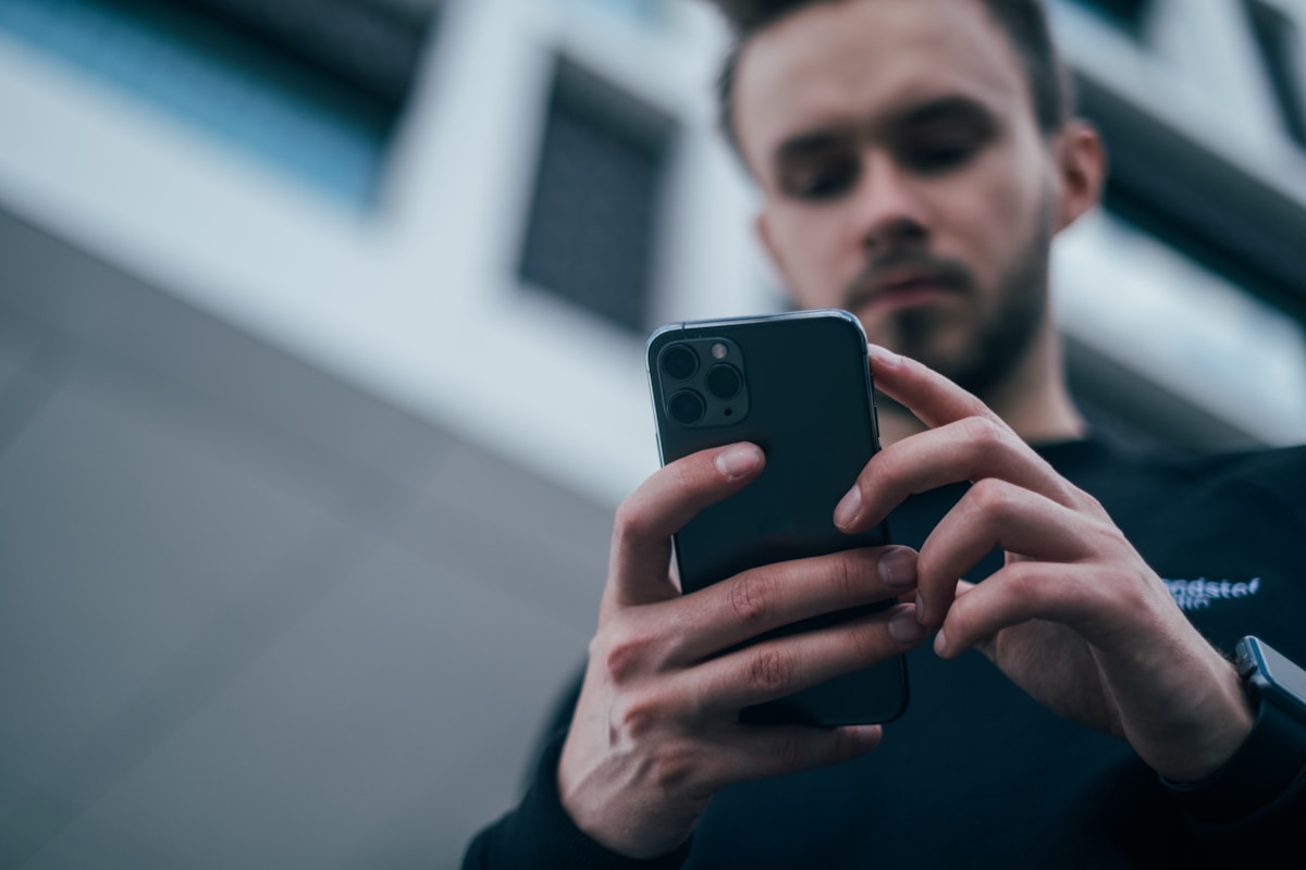 5 apps para monitorar avaliações online e manter sua reputação man wearing black sweater using smartphone