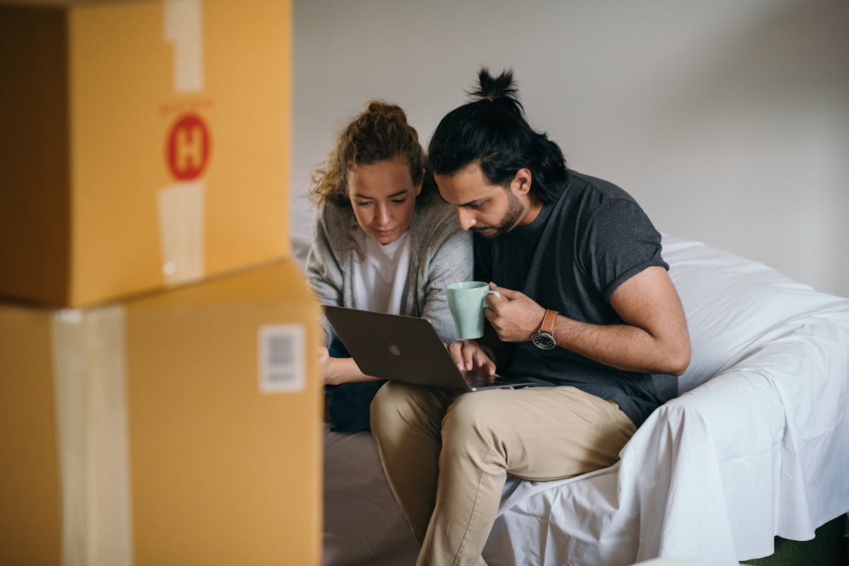 5 apps para encontrar o imóvel dos seus sonhos Young multiethnic couple watching laptop while moving house