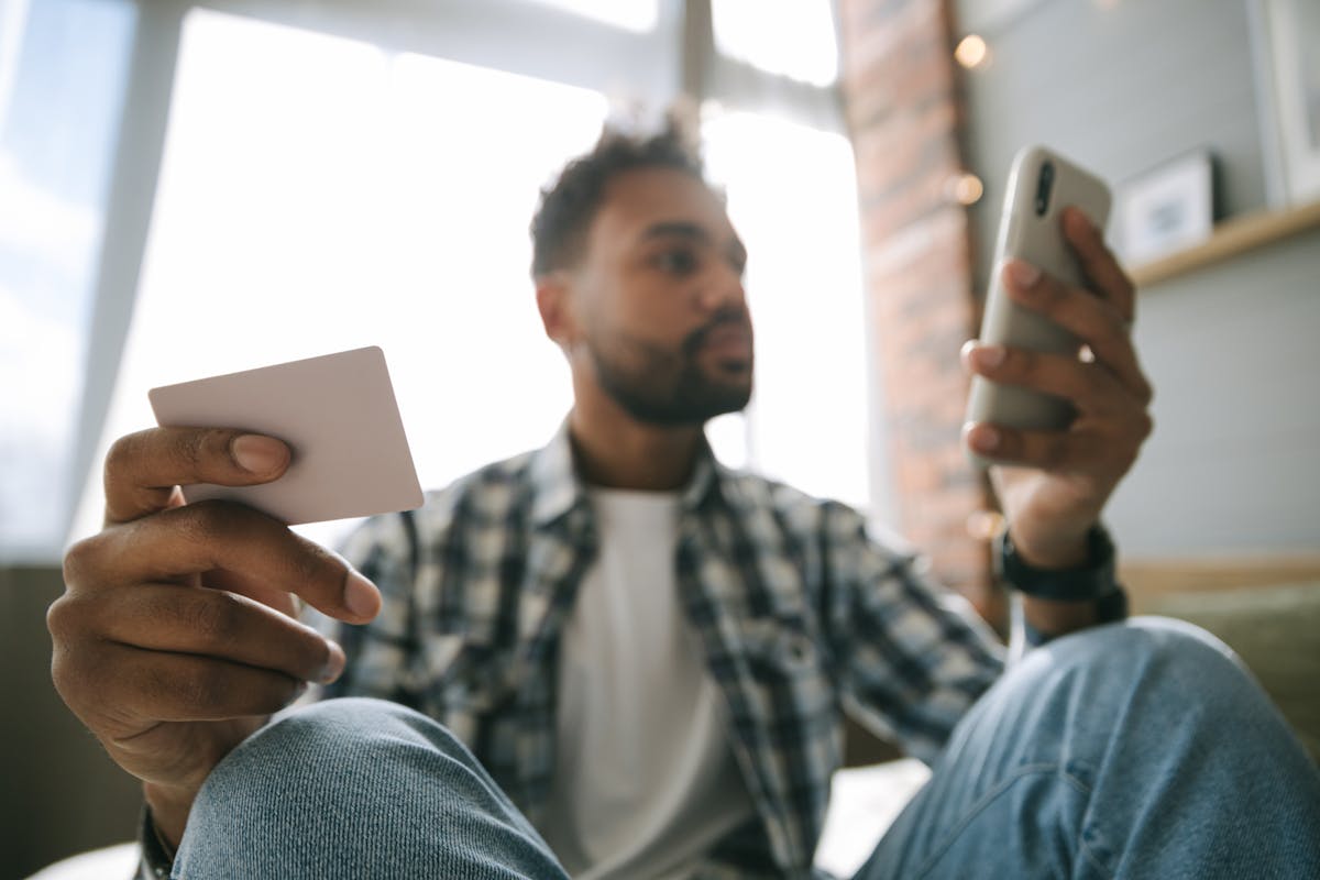 5 Apps para monitorar gastos e melhorar suas finanças Close Up Photo of a Man Holding Cellphone and a Card