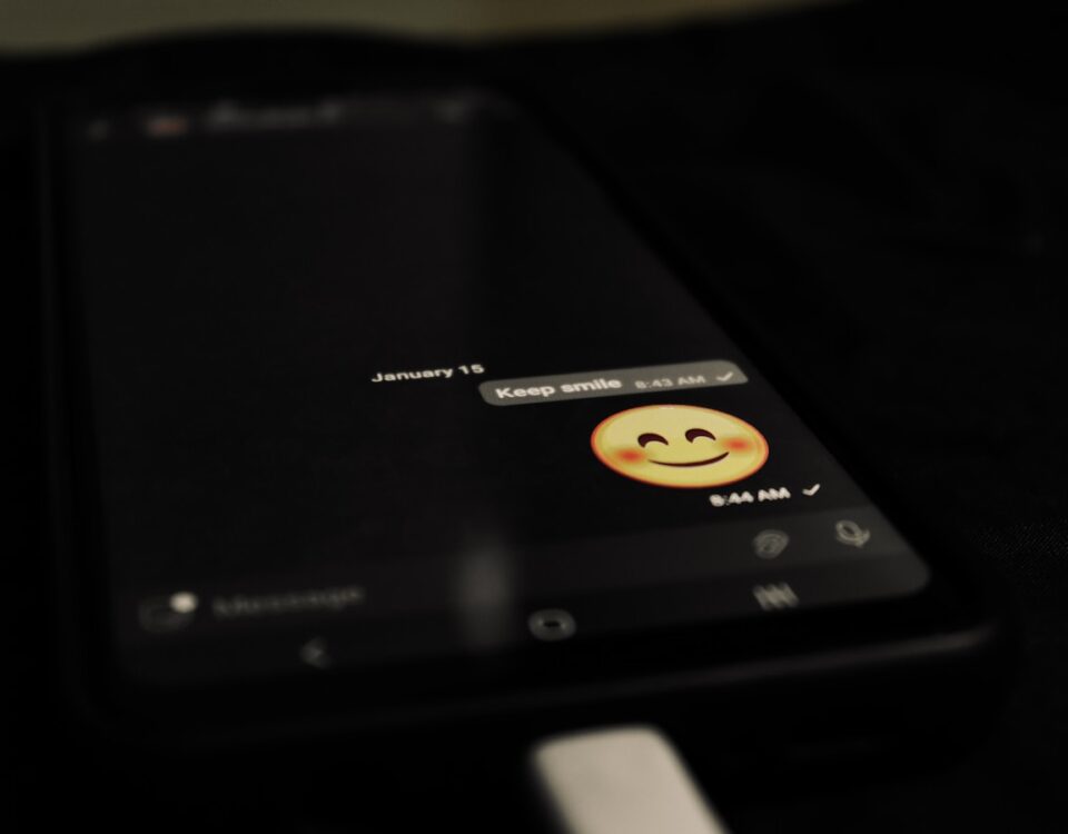 Entenda como funcionam os softwares para criar chatbots no WhatsApp a cell phone with a smiley face on the screen