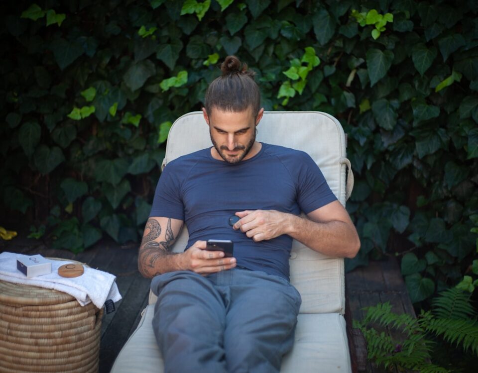 5 apps para lidar com a depressão e melhorar o humor a man sitting in a chair looking at a cell phone