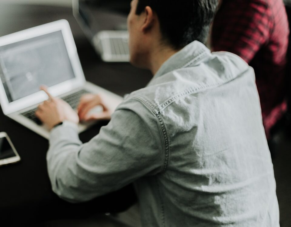 O que é um ERP e por que ele é essencial para empresas? a man sitting at a table using a laptop computer