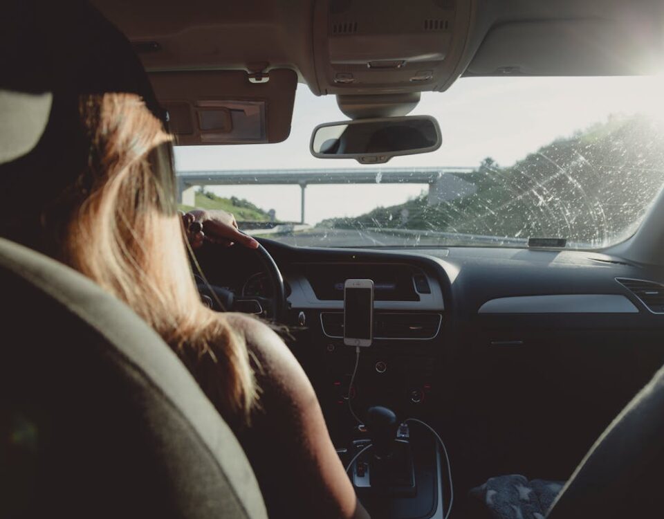5 apps que ensinam técnicas de direção defensiva Woman driving on a highway during daytime, capturing road trip mood.