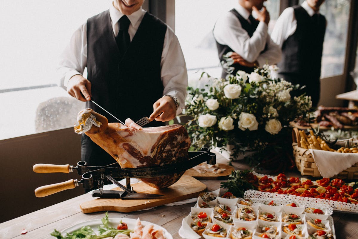 Smiling waiter slicing ham at a Beirut restaurant buffet, creating a welcoming dining atmosphere.