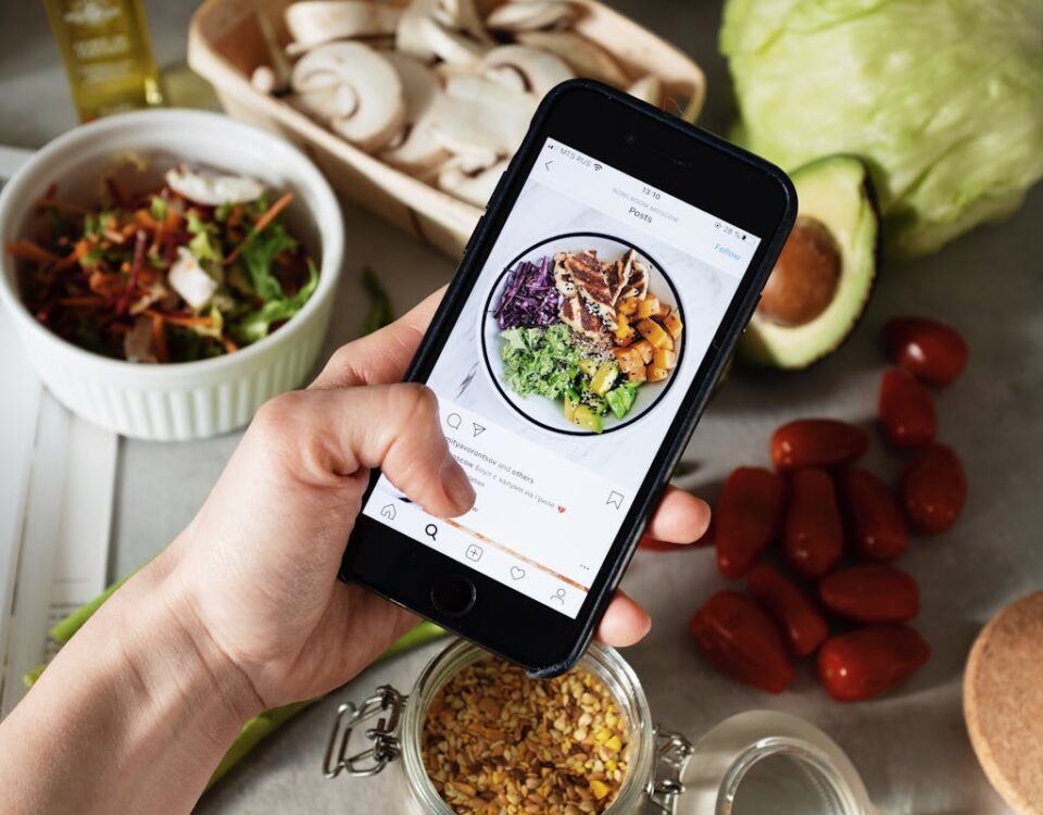 5 apps para criar conteúdo atrativo no Instagram Person takes photo of healthy salad ingredients for social media in kitchen.