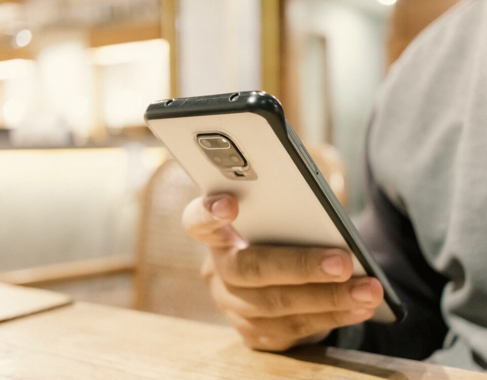 5 apps que monitoram sintomas de doenças inflamatórias A person sitting at a table with a cell phone