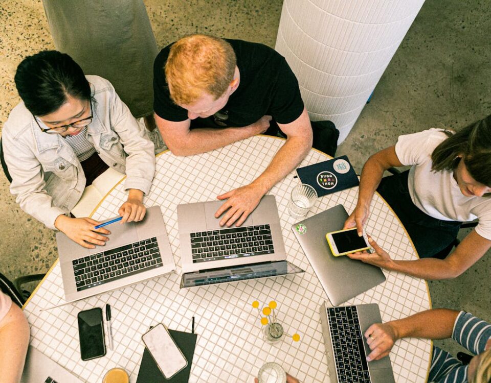 5 softwares para gerenciar projetos com agências criativas Top view of diverse team collaboratively working in a modern office setting.