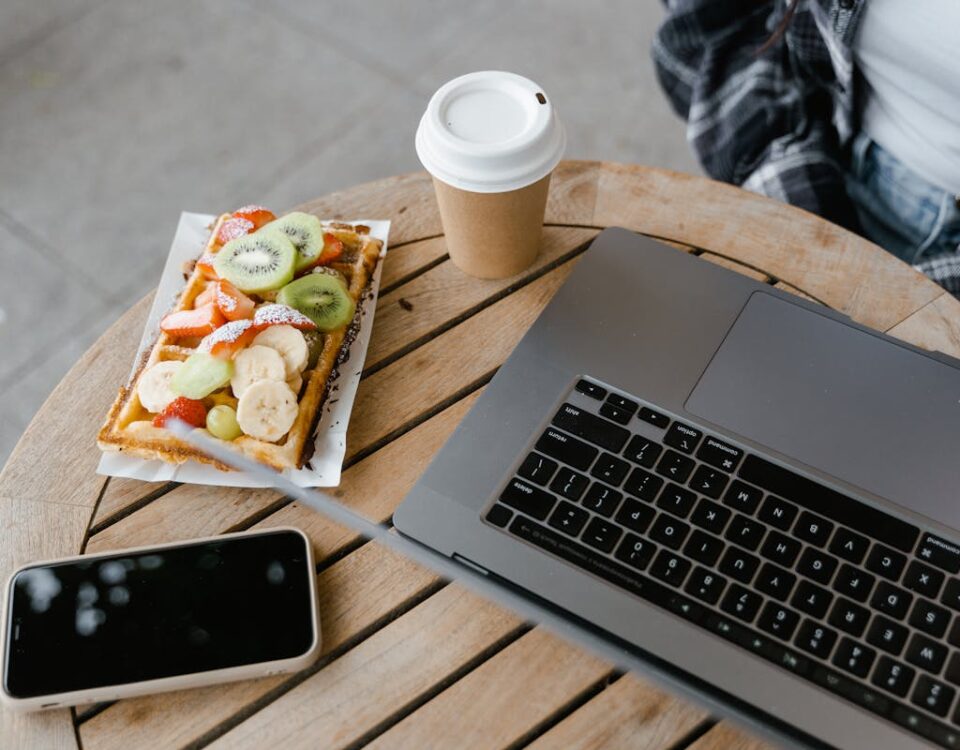5 apps que ajudam a planejar suas refeições Cozy cafe scene with a waffle, coffee, and a laptop. Perfect for remote work lifestyle.