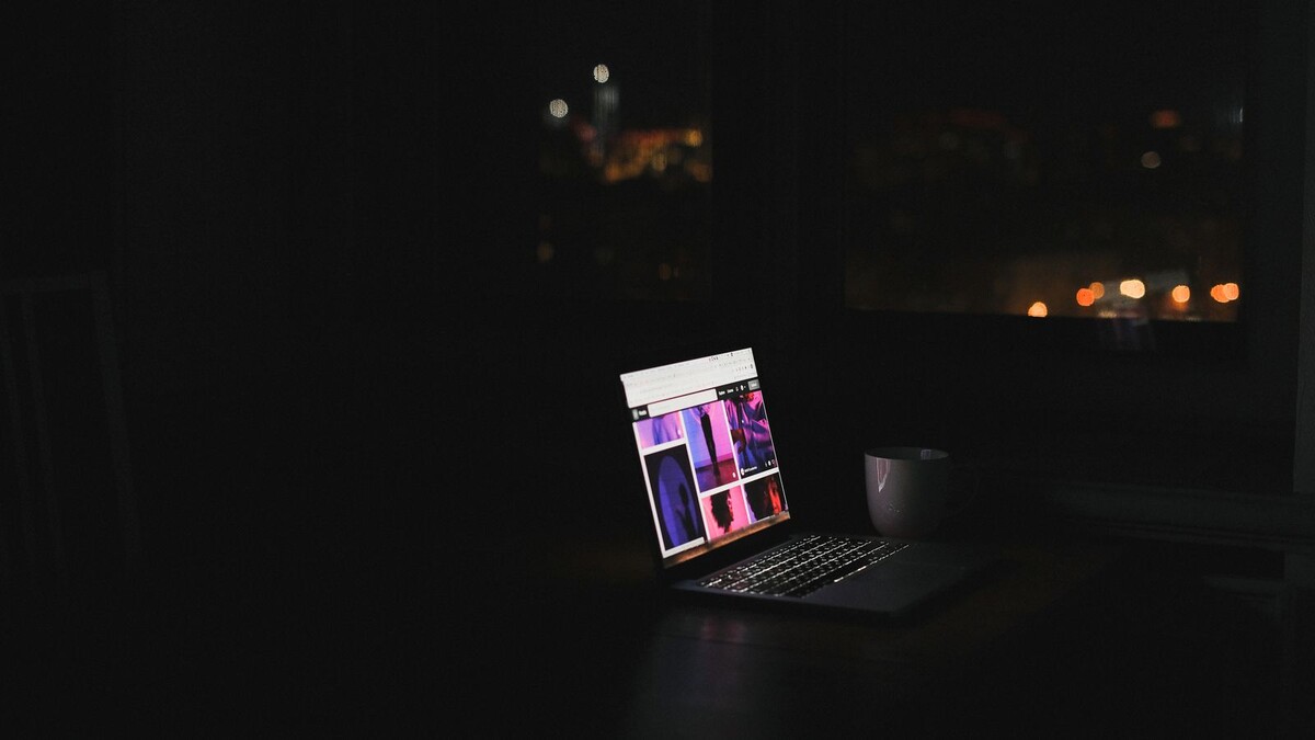 ChatGPT no Chrome agora age nas suas abas: como ativar com segurança Notebook aberto ao lado de uma xícara em um ambiente escuro