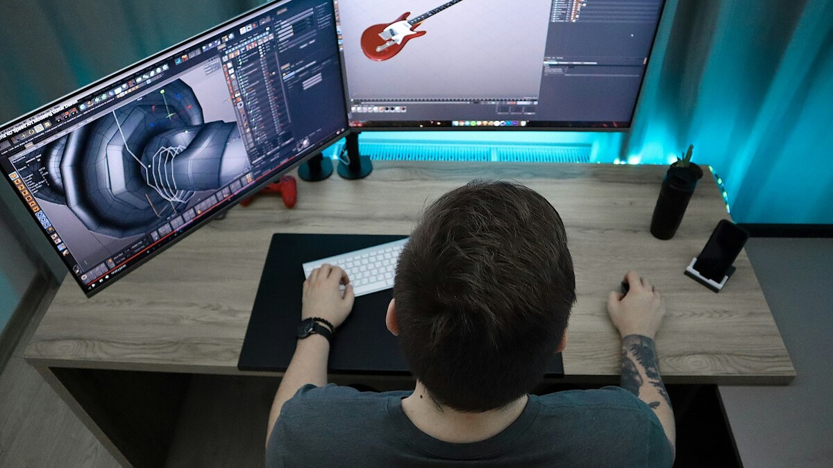 Pessoa trabalhando em modelo 3D em dois monitores