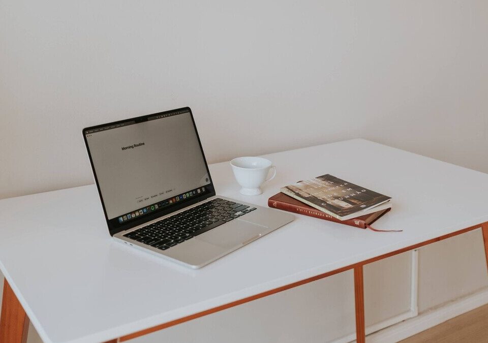 Notebook e livros em mesa de trabalho