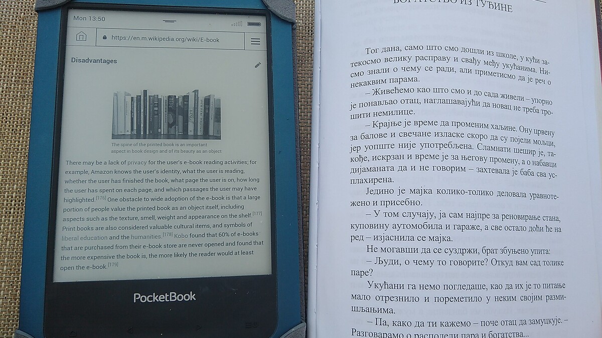 Leitor de livros digitais ao lado de um livro impresso aberto