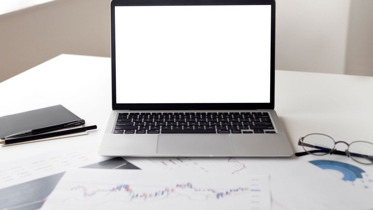 Meta adia novos termos comerciais para 20/11: o que o anunciante revisa Notebook aberto com tela em branco sobre mesa com documentos e gráficos