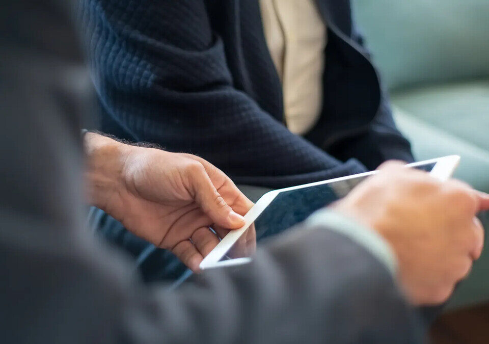Portal do cliente: quais funções valem num sistema próprio Profissionais analisando informações no tablet
